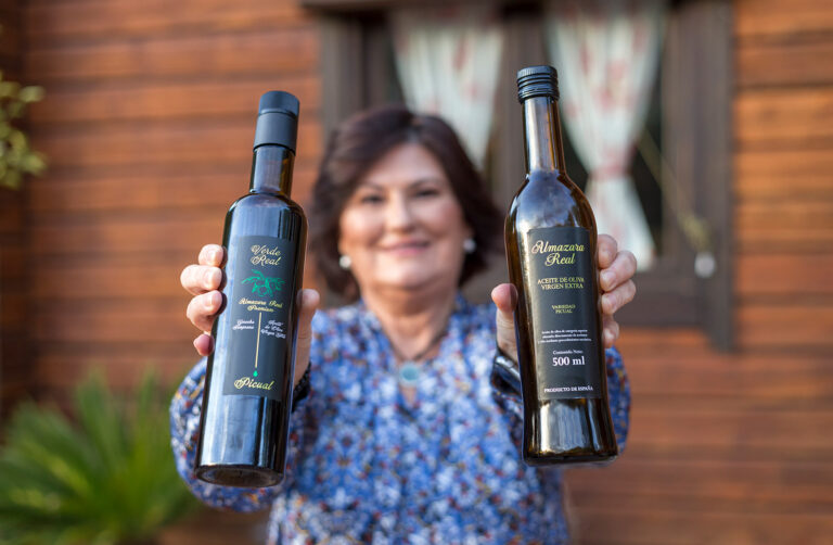 Leonor Guerrero mostrando dos botellas de Aceite de Oliva Virgen Extra Picual de Almazara Real Mancha Real Jaén